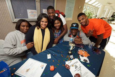 3 men. 3 women. Students smiling around table.