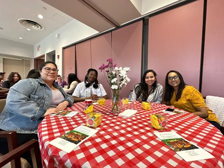 Staff, faculty and students seated together at a table.