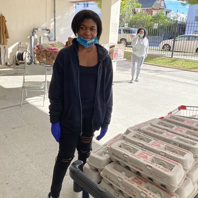 Felicia Archer stands in front of table of eggs at the food pantry