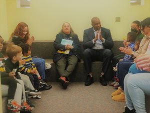 President Daisy Cocco De Filippis reading to children alongside VP Yates of SDEM